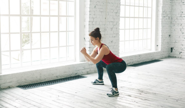 Mujer realizando una sentadilla correcta con buen control motor y alineación de rodillas